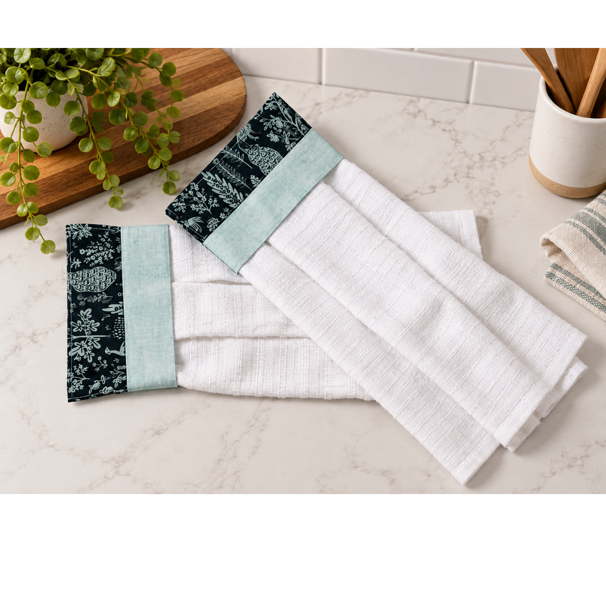 Set of kitchen hand towels sitting on a marble countertop.